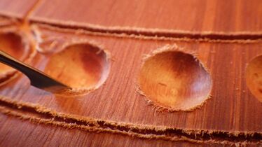 since the 4-player board's hardwood fibers were easily cut by a knife, sanding and the resulting brightening of the Eukalyptus wood could be largely avoided during the cleanup process