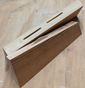 two small boards used as test for the biscuit joiner. Each board has two grooves made by the joiner, one of the grooves has a biscuit inserted.