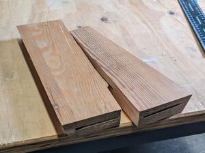 two small boards used as test for the biscuit joiner. Each board has two grooves made by the joiner, one of the grooves has a biscuit inserted.